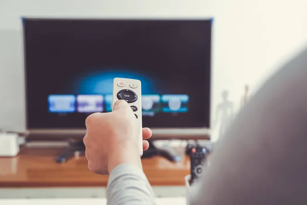 Una mano delle donne tenere il telecomando del televisore in soggiorno — Foto Stock