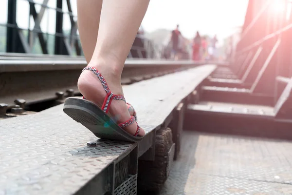 Primer plano de la zapatilla zapatillas de viaje mientras camina en el día soleado en el puente ferroviario — Foto de Stock