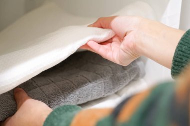 kadın el raf banyoda bir havlu havlu yığını üzerinden alarak kapatmak