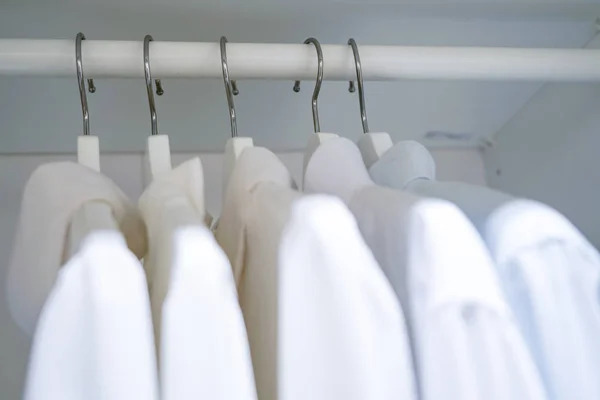 Řada mužů a žen košile na ramínko, visí ve skříni — Stock fotografie