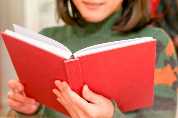 Açık kırmızı kitap holding/evde kadın el üzerinde okuma — Stok fotoğraf