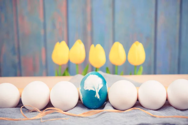 Happy Easter, organic blue easter egg in the middle of white color eggs wait for painting, easter holiday decorations, easter concept backgrounds with copy space