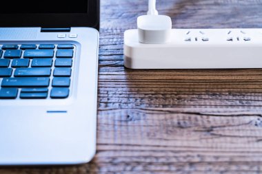 düz bilgisayar dizüstü ve beyaz tak soketine ve ahşap çalışma masa kopya alanı ile yatıyordu kompozisyon Üstten Görünüm