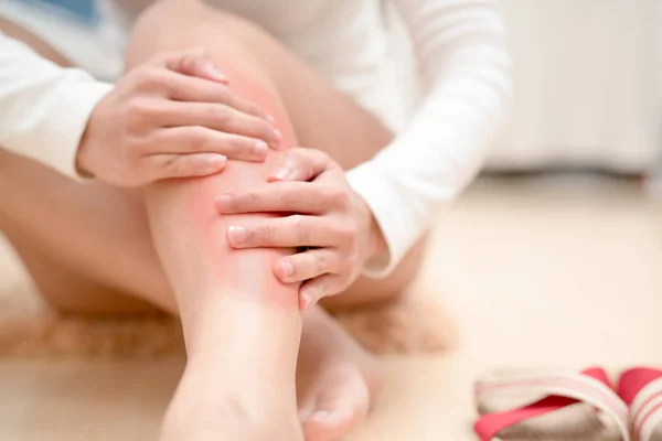 腿部踝关节受伤疼痛的妇女抚摸腿部疼痛与红色突出的伤害。医疗保健理念 — 图库照片