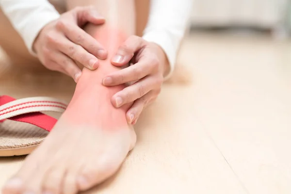 Lesão no tornozelo perna mulheres dolorosas tocando a perna dolorosa com destaque vermelho na lesão. conceito médico e de cuidados de saúde — Fotografia de Stock