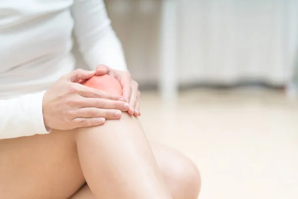 Dolor de rodilla lesiones mujeres sentadas y tocándose la rodilla dolor, cuidado de la salud y medicina concepto — Foto de Stock