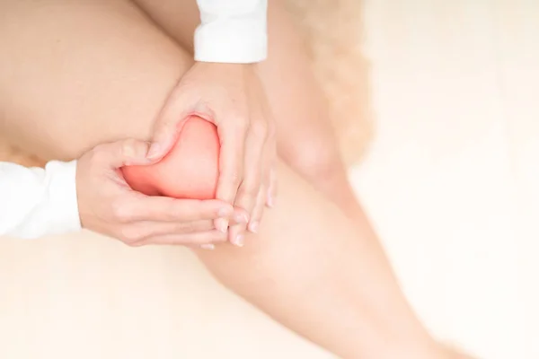 Dolor de rodilla lesiones mujeres sentadas y tocándose la rodilla dolor, cuidado de la salud y medicina concepto — Foto de Stock