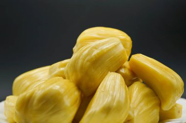 Beyaz tabakta taze meyve dilimleri. Tatlı sarı meyveler olgunlaşmış. Vejetaryen, vejetaryen, çiğ yemek. Egzotik tropikal meyve - izole