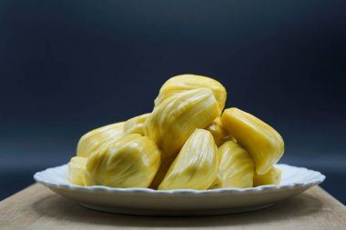 Beyaz tabakta taze meyve dilimleri. Tatlı sarı meyveler olgunlaşmış. Vejetaryen, vejetaryen, çiğ yemek. Egzotik tropikal meyve - izole