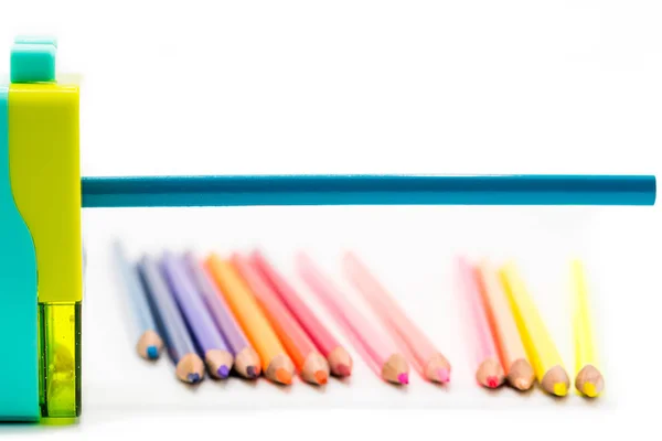 Pastel azul amarillo rotatorio lápiz afilador virutas con lápices de madera de colores aislados sobre fondo blanco, volver al concepto de educación escolar — Foto de Stock