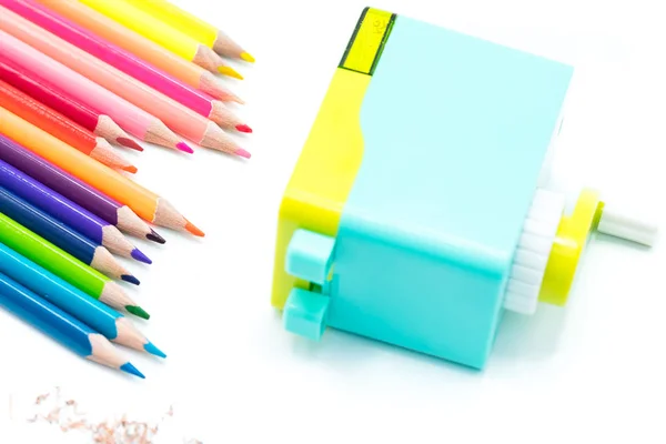 Pastel blue yellow rotary pencil sharpener shavings with wooden colorful pencils isolated on white background, back to school education concept — Stock Photo, Image