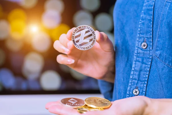 cryptocurrency - Litecoin, Ethereum, Bitcoin, dalgalanma paraları. Kadınlar cryptocurrency para el üstünde tutun. Fiziksel bitcoins altın ve gümüş sikke