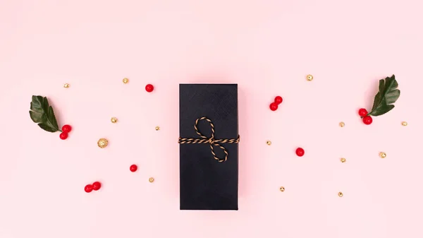 Karácsonyi ajándékdoboz, piros cseresznye és arany dekoráció rózsaszín háttérrel. Karácsony, tél, újévi koncepció. Lapos fekvés, felülnézet, másolás — Stock Fotó