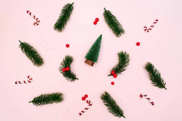 Christmas pine tree with Xmas decoration on pink background, flat lay composition — Stock Photo, Image