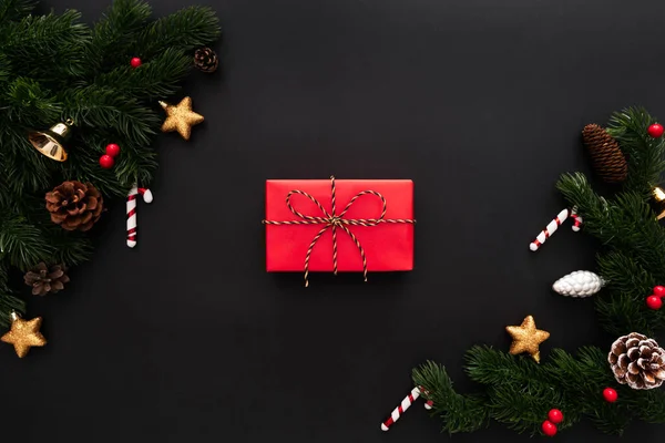 Christmas gift box and pine tree with xmas decoration on black background — Stock Photo, Image