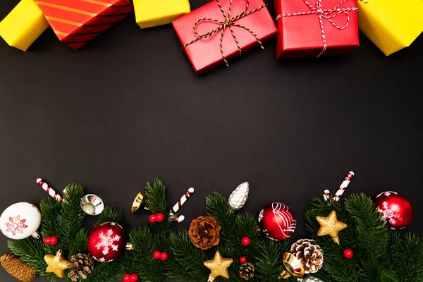 Christmas gift box and pine tree with xmas decoration on black background — Stock Photo, Image
