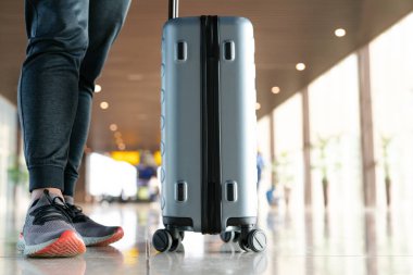 Bavullu gezgin hava yolculuğu için havaalanı terminalinde valiz taşıyordu.