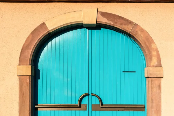 Голубая деревянная дверь на фоне кирпичной цементной стены — стоковое фото