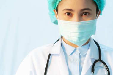 Coronavirus enfeksiyonu durdurur. Bulaşıcı hastalıklara ve gribe karşı steteskoplu maske takan genç bir bayan doktor. Sağlık hizmetleri kavramı