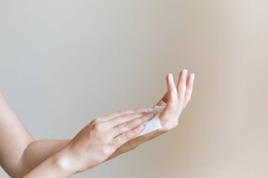 Kadın ellerini beyaz yumuşak mendil kağıdıyla temizliyor. Beyaz bir arka planda izole edilmiş