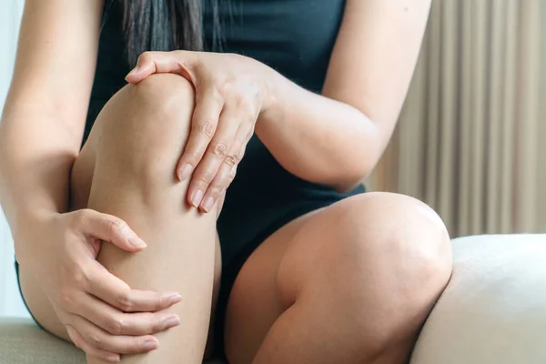 women knee painful, women touch the pain knee at home