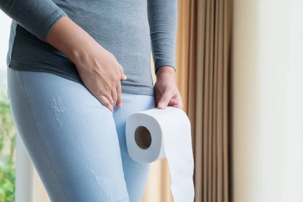 Disorder, Diarrhea, incontinence. Healthcare concept. Woman hand holding her crotch lower abdomen and tissue or toilet paper roll. — Stock Image Disorder Diarrhea Incontinence Healthcare Concept Woman Hand Holding Her Crotch Stock Photo