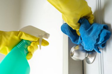 Covid-19 Coronavirus önleme için alkol spreyi ile kapı tokmağı temizleme