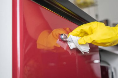 Covid-19 Coronavirus önleme için alkol spreyi ile kapı kolunu temizliyorum.