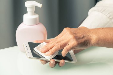 Covid-19 Coronavirus el temizleme akıllı telefon konsepti, son sınıf el temizleme akıllı telefonu alkol jeli veya bakteri jeli ile temizlik yapmak ve temiz virüs, mikrop, bakteri, bakteri