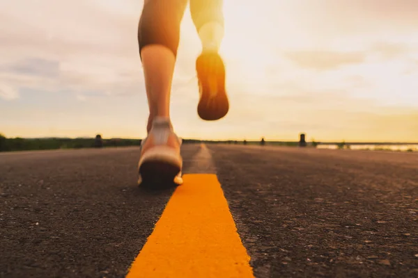 Gün batımında koşan bir sporcu maraton ve spor için antrenman yapıyor. Dışarıda egzersiz yapan bir kadının hareket bulanıklığı.