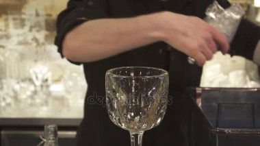 Buz küpü kokteyl cam tutan barmen. Barmen alkollü kokteyller hazırlanıyor. yakın çekim.