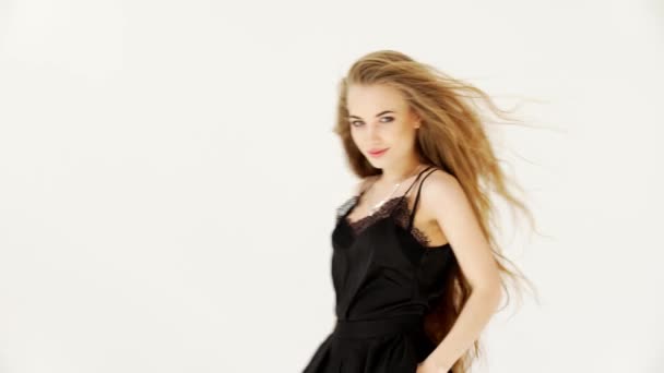 Девушка позирует модель, улыбается, реклама одежды на белом фоне — стоковое видео