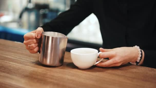 Ella observa como el Barista añade la leche en el café. En cámara lenta. Primer plano . — Vídeo de stock