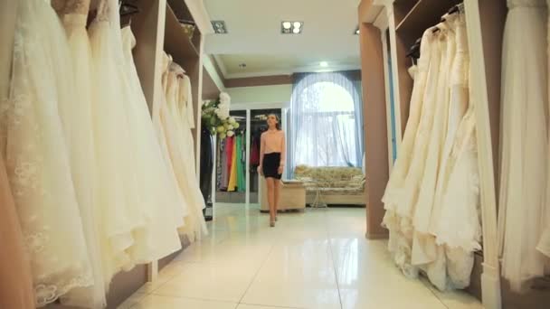 Lächelnde hübsche Braut wählt Hochzeitskleid in Brautboutique — Stockvideo
