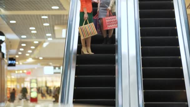 Jovens mulheres felizes bonitas na escada rolante do shopping — Vídeo de Stock