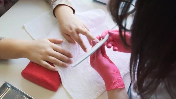 Vrouw handen ontvangen een manicure in schoonheidssalon. Nagelvijl. Close-up, selectieve focus. — Stockvideo