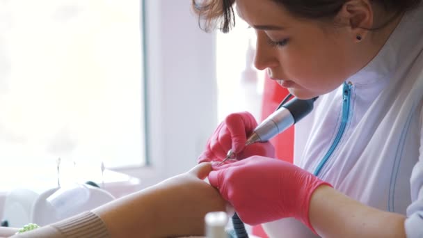 Primo piano di master utilizza una macchina elettrica per rimuovere lo smalto durante la manicure nel salone. Manicure hardware. Concetto di cura del corpo — Video Stock