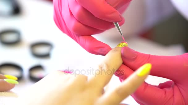 Primer plano de un esteticista aplicando esmalte de uñas a las uñas femeninas en un salón de uñas. Primer plano de una mano de mujer con esmalte de uñas amarillo después de la manicura . — Vídeo de stock