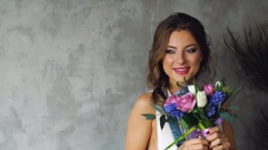 sarı saçları ve çiçek lale, gül, gri bir arka plan üzerinde bir sürü kızla