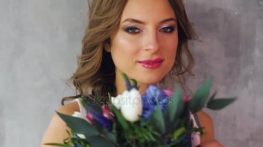 sarı saçları ve çiçek lale, gül, gri bir arka plan üzerinde bir sürü kızla