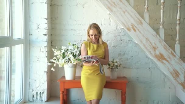 Дівчина в гірчичній сукні дивитися журнал — стокове відео