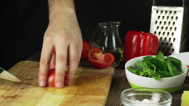 Нож режет помидор на деревянной доске — стоковое видео