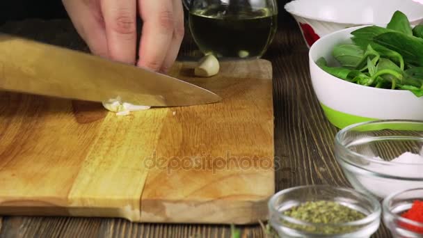 De chef-kok plakjes de knoflook. Mes, hakken Board, knoflook. Snel snijden van groenten. Knoflook. Knoflook voor frituren. De handen van de kok. — Stockvideo