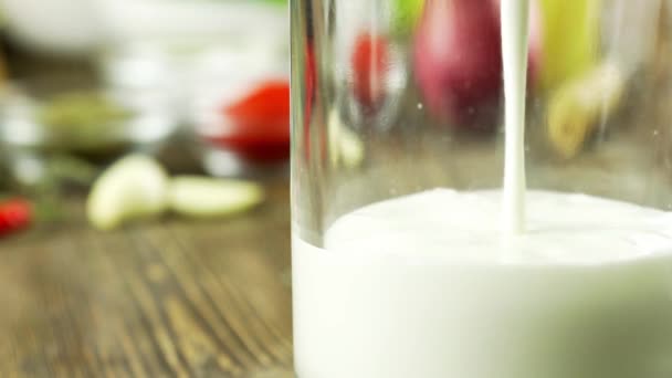 A mandula-tejet öntenek egy pohár, ban lassú mozgás, a háttérben ott erdőben mandula, tökéletes részére diéta egészséges táplálkozás és gyógyszerként használható. koncepció: diéta, fitness, gyógyászat. — Stock videók