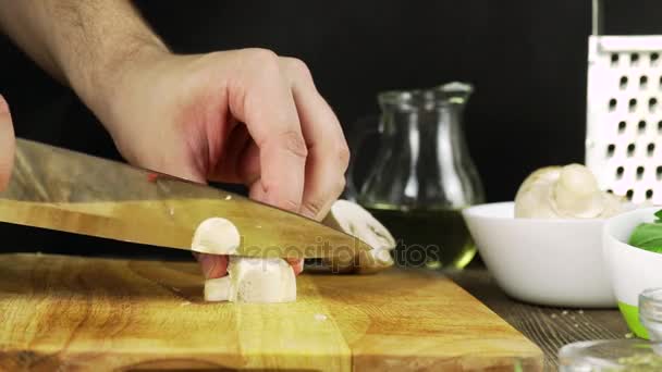 Manos de hombre cortando en rodajas champiñones champiñón de Paris verduras en la cocina, primer plano — Vídeo de stock