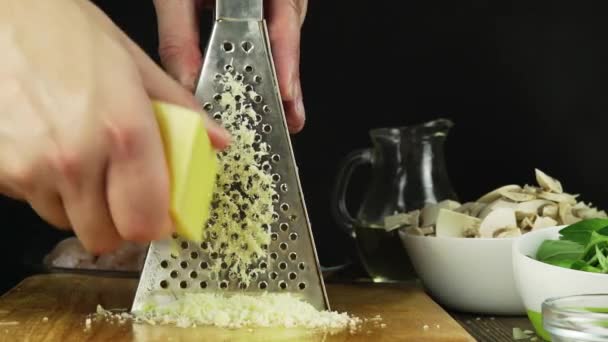 Um chef esfrega queijo parmesão . — Vídeo de Stock