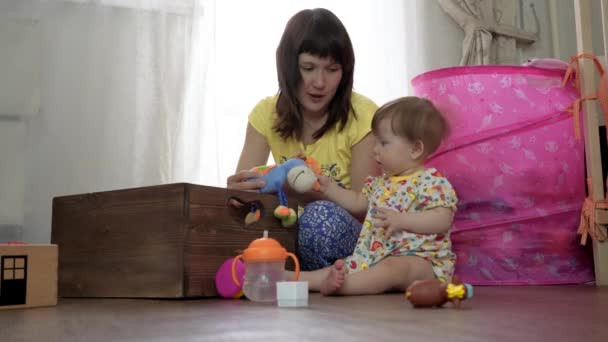 Mamãe brinca com uma criança pequena em um quarto no chão — Vídeo de Stock