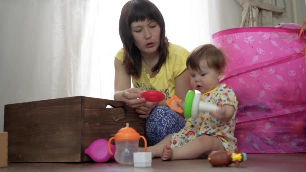 Mamá juega con un niño pequeño en una habitación en el suelo — Vídeos de Stock