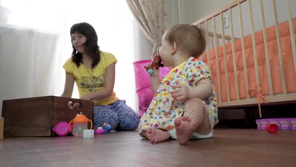 Mamá juega con un niño pequeño en una habitación en el suelo — Vídeos de Stock