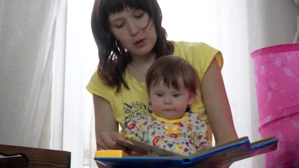 Matka i córka czytają razem książkę — Wideo stockowe